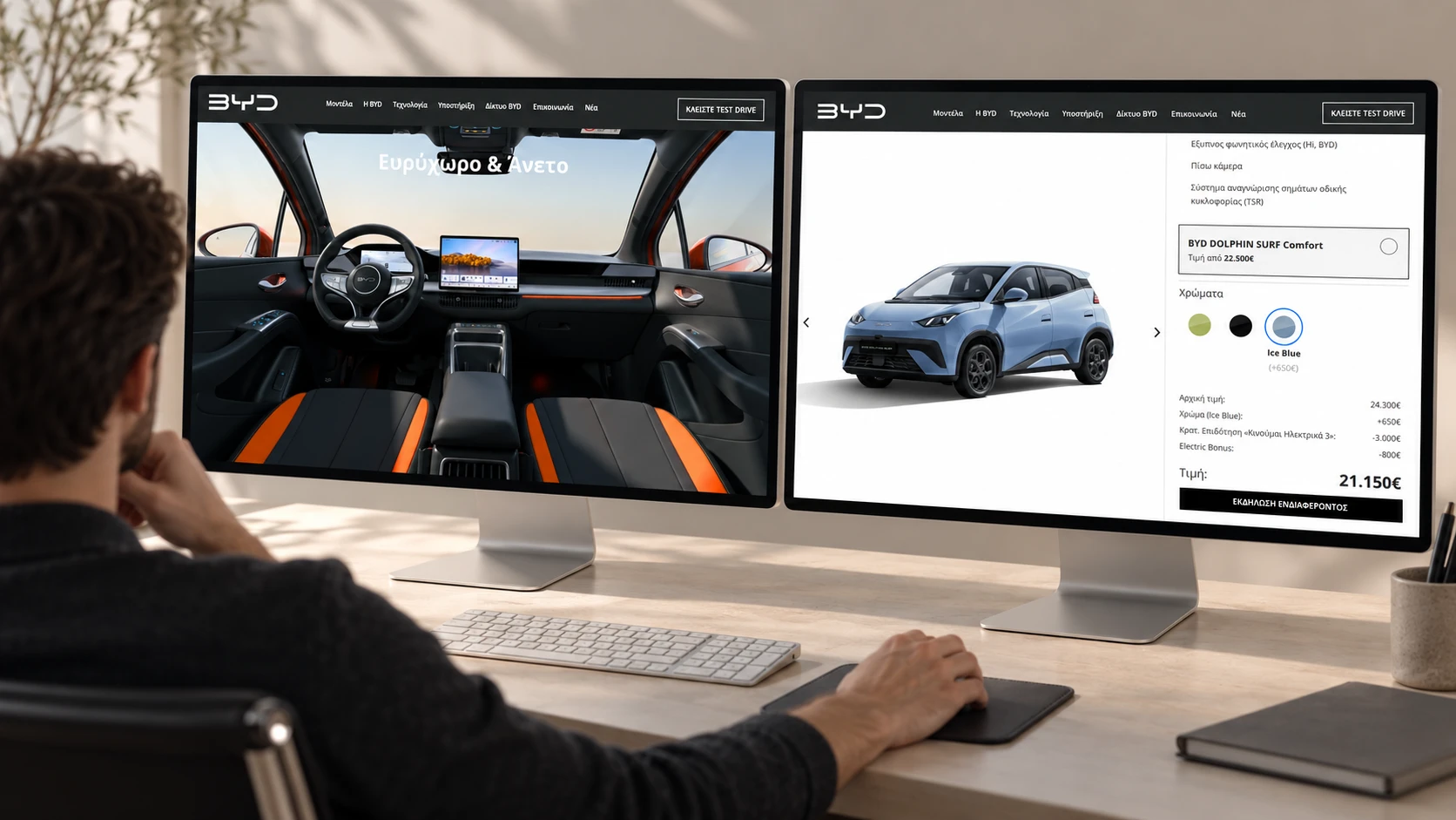 A person looking at two Mac displays: the BYD model page on the left and the DOLPHIN SURF configurator on the right.